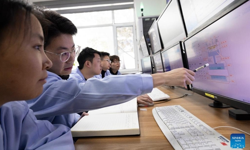 Các nhà nghiên cứu phân tích dữ liệu thực nghiệm tại phòng điều khiển của cơ sở máy gia tốc ion nặng cường độ cao năng lượng thấp (LEAF) ngày 10/12/2024. Ảnh: Tân Hoa xã
