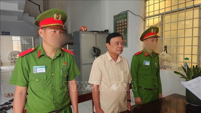 Thi hành lệnh bắt tạm giam đối với Trần Minh Vũ. (Ảnh: TTXVN phát)