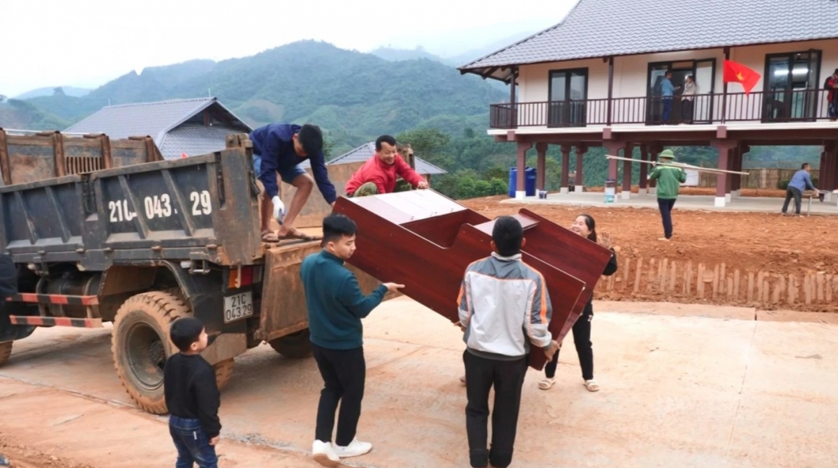 Nu villagers move their belongings to new stilt houses in the resettlement area.