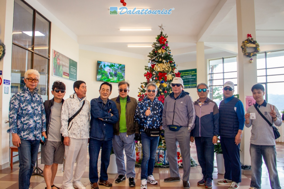 Du khách chụp ảnh lưu niệm với cây thông Noel tại khu vực ga đi Cáp treo Đà Lạt