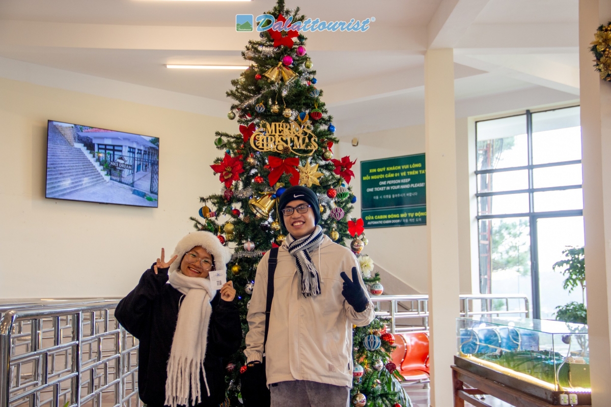 Du khách check-in với cây thông Noel tại nhà ga cáp treo.