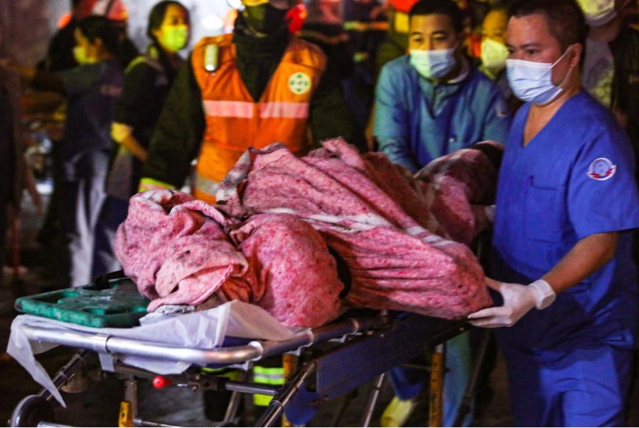 Đưa người bị nạn ra khỏi hiện trường vụ cháy - Ảnh: NGỌC NGUYỄN (Tuổi trẻ)