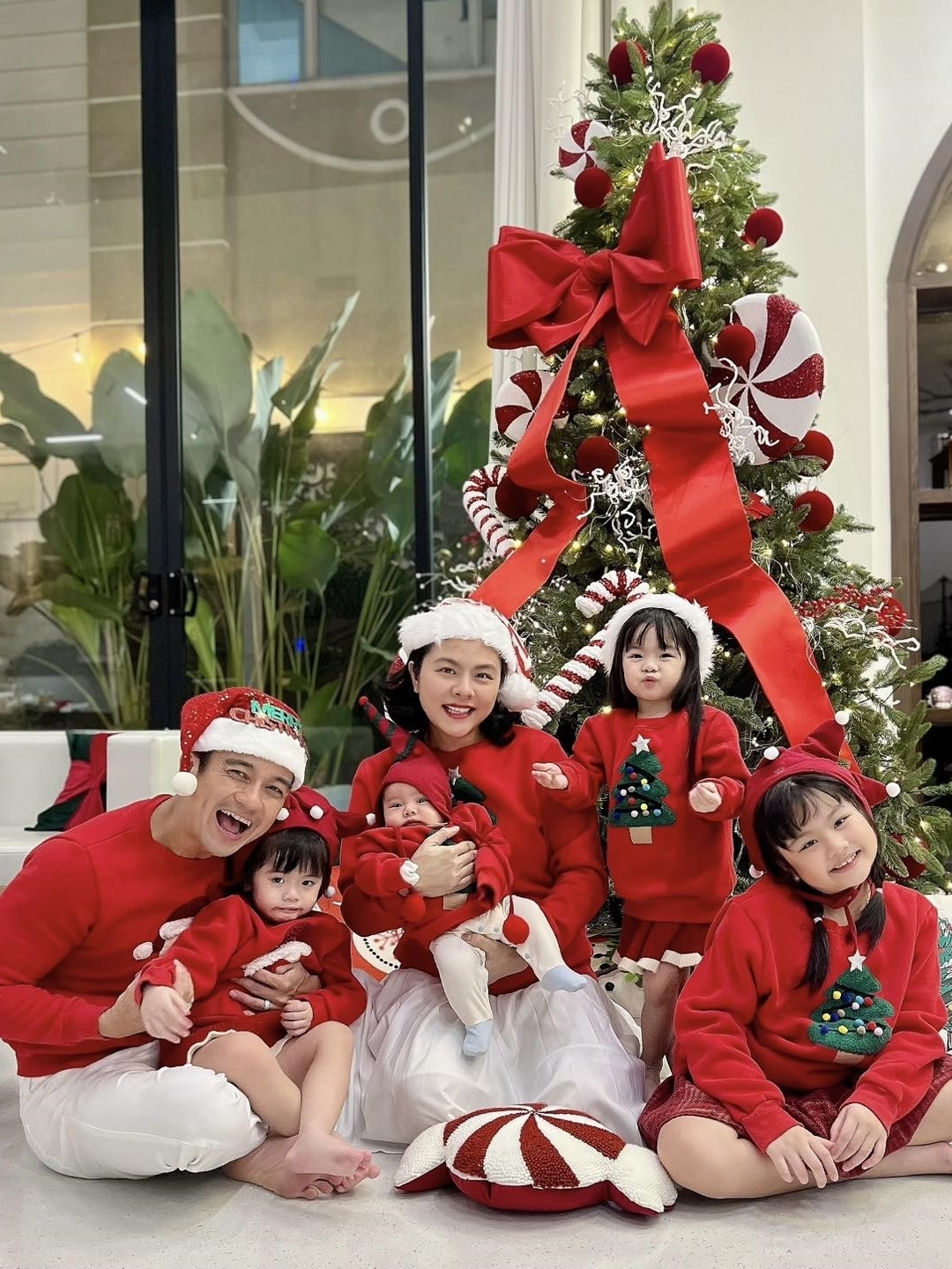 Gia đình Vân Trang quây quần bên cây thông Noel cao gần 3 mét, chụp ảnh lưu niệm trong không gian ấm cúng. Vợ chồng diễn viên cùng 4 con: Queenie, 9 tuổi, cặp song sinh Quinita - Quianna, ba tuổi, và bé út Q Junior, hai tháng tuổi, tỏ ra háo hức khi hưởng khoảnh khắc bình yên.