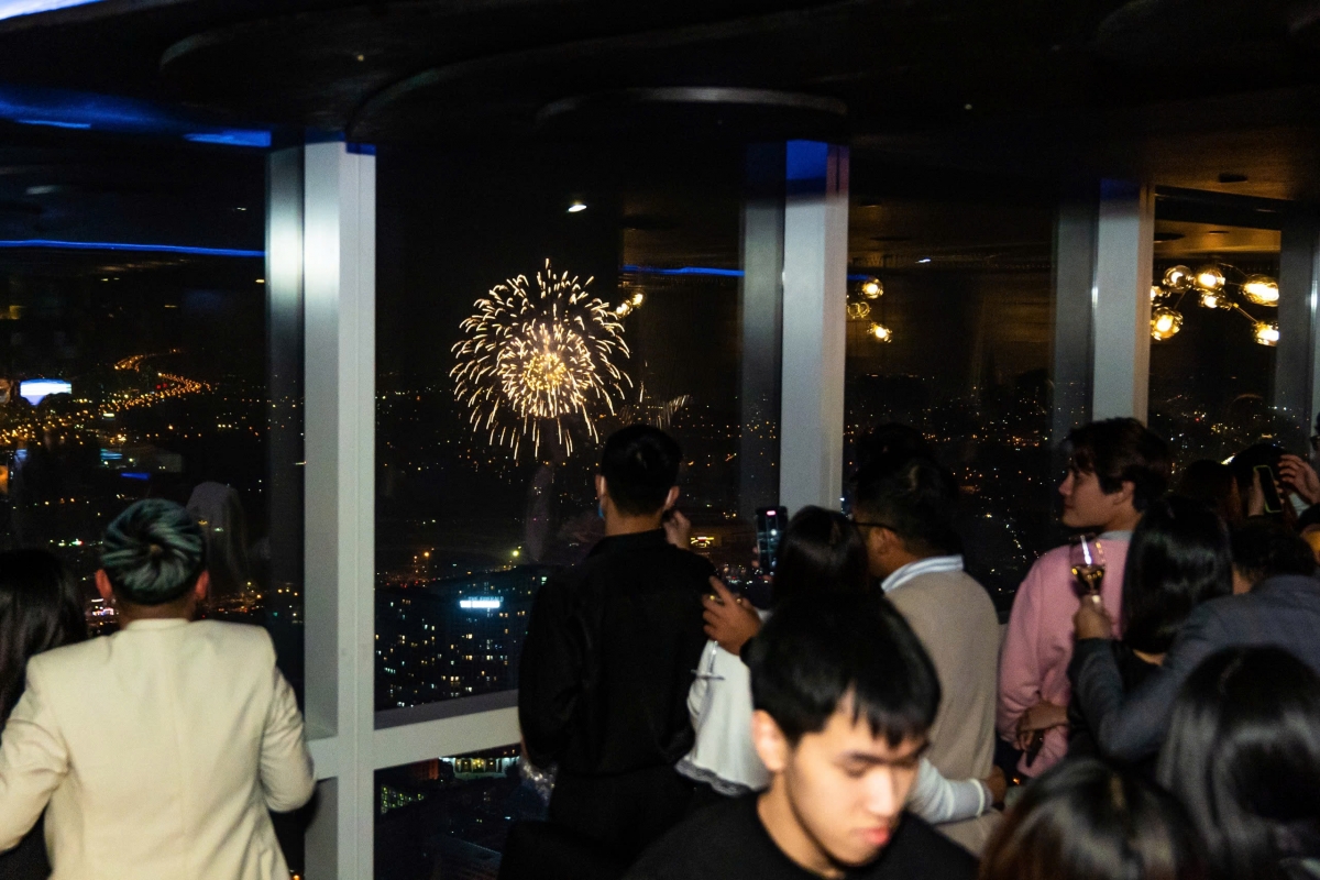 Du khách ngắm pháo hoa từ một nhà hàng của InterContinental Hanoi Landmark72.