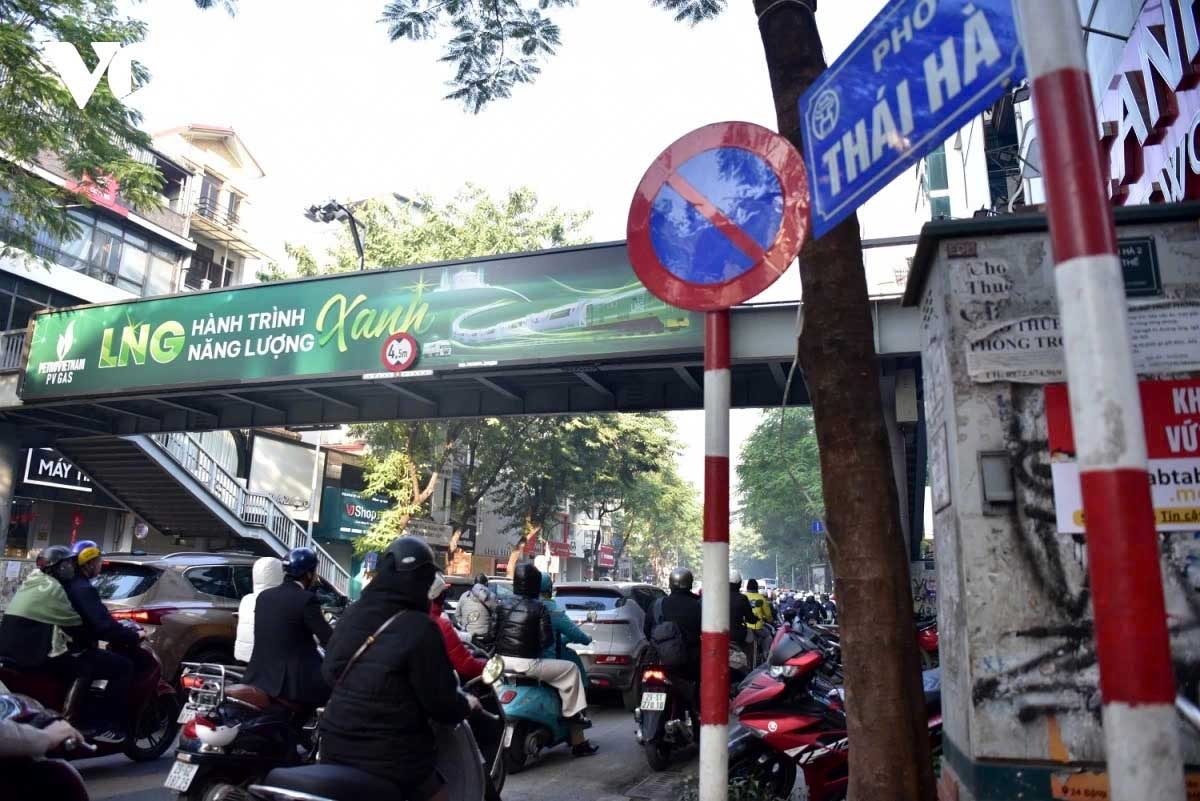 On Thai Ha Street, during peak hours, long lines of vehicles and pedestrians move at a slow pace. The congestion is compounded by traffic lights at intersections, which create bottlenecks as streams of vehicles struggle to pass through.