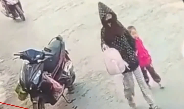 Hình ảnh bé gái bị người phụ nữ dẫn đi. (Ảnh cắt từ clip)