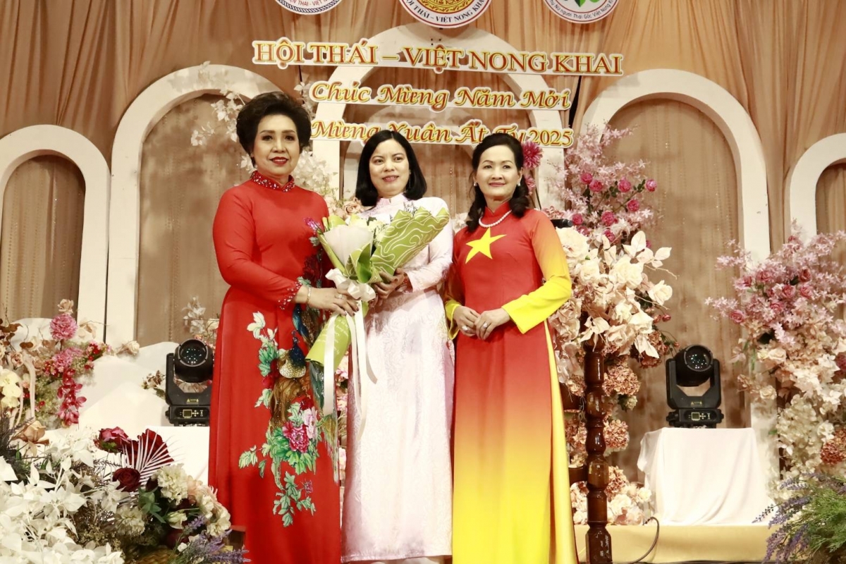 Đại diện Tổng Lãnh sự quán Dương Thị Thế (giữa) tặng hoa Chủ tịch Ban Phụ nữ kiều bào toàn Thái Đinh Thị Kim Loan (trái).