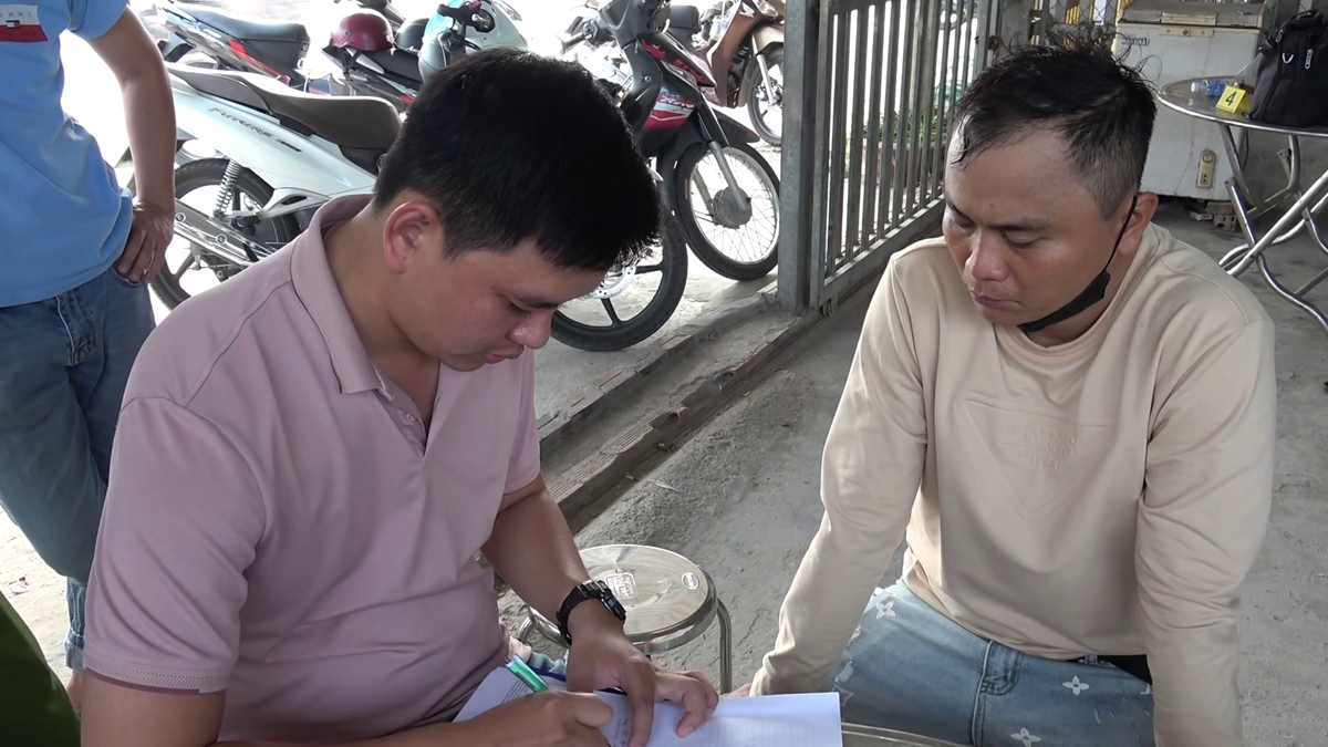 Một đối tượng trong vụ đốt pháo hoa (bên phải) làm việc với cơ quan chức năng.