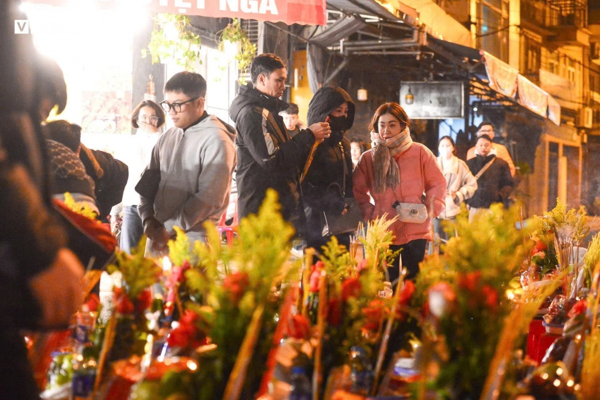 Do cổng chính quá đông, một số người chọn mang đồ lễ sang cổng phụ để thắp hương.