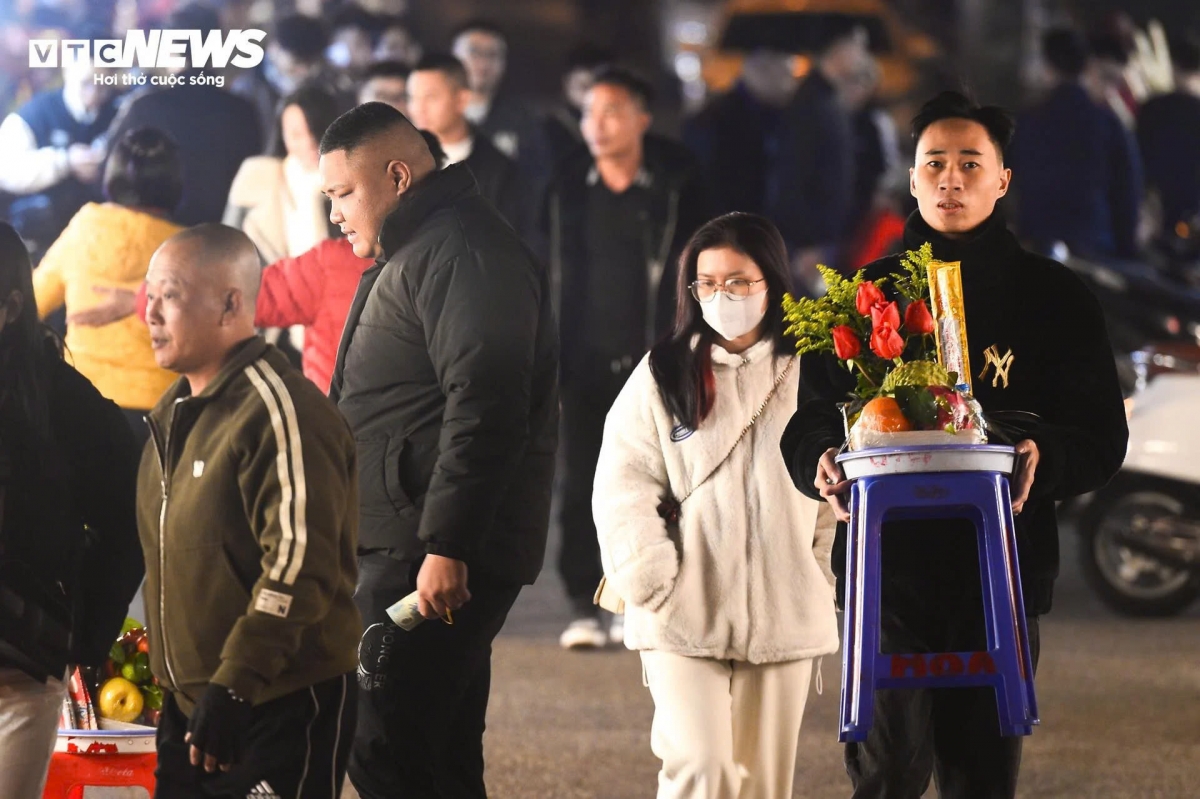 Người dân mặc áo ấm, choàng khăn bê lễ vào Phủ Tây Hồ trong ngày rằm cuối cùng năm Giáp Thìn.