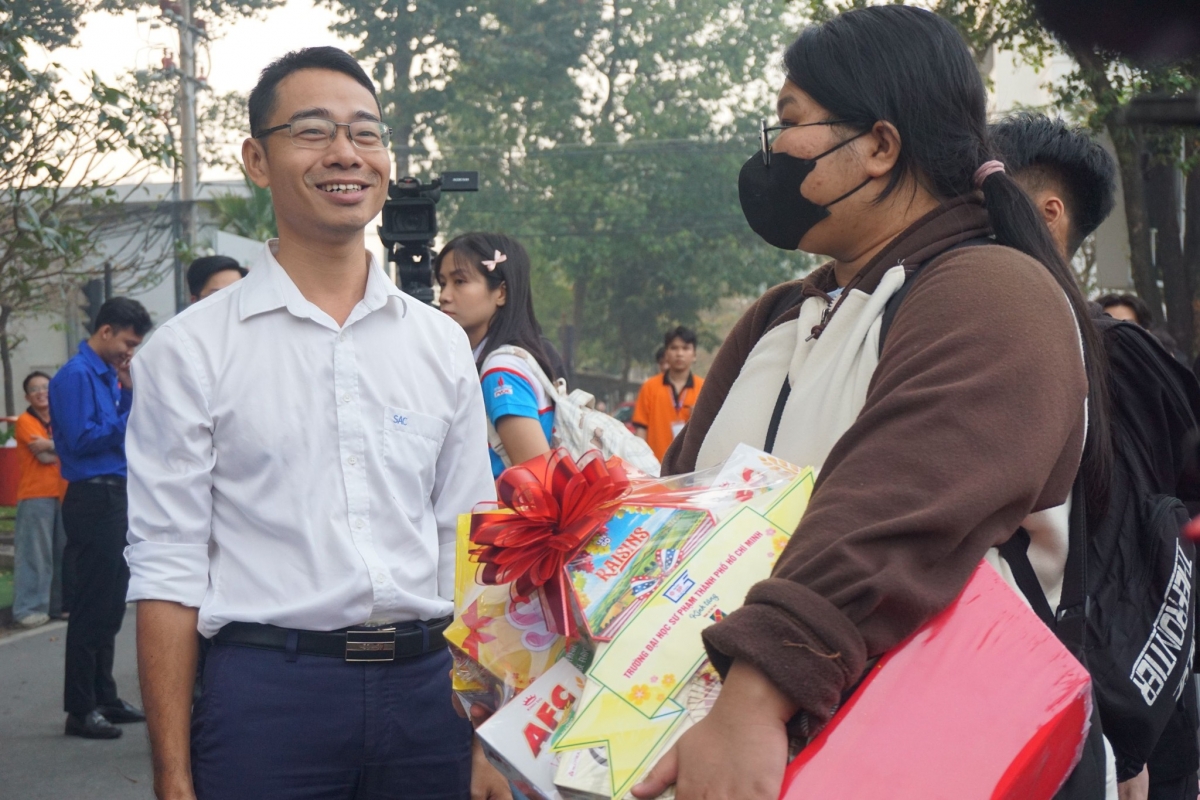 Đại diện Trung tâm Hỗ trợ học sinh, sinh viên TP.HCM tặng quà Tết cho sinh viên trước khi lên xe về quê (ảnh: SAC)
