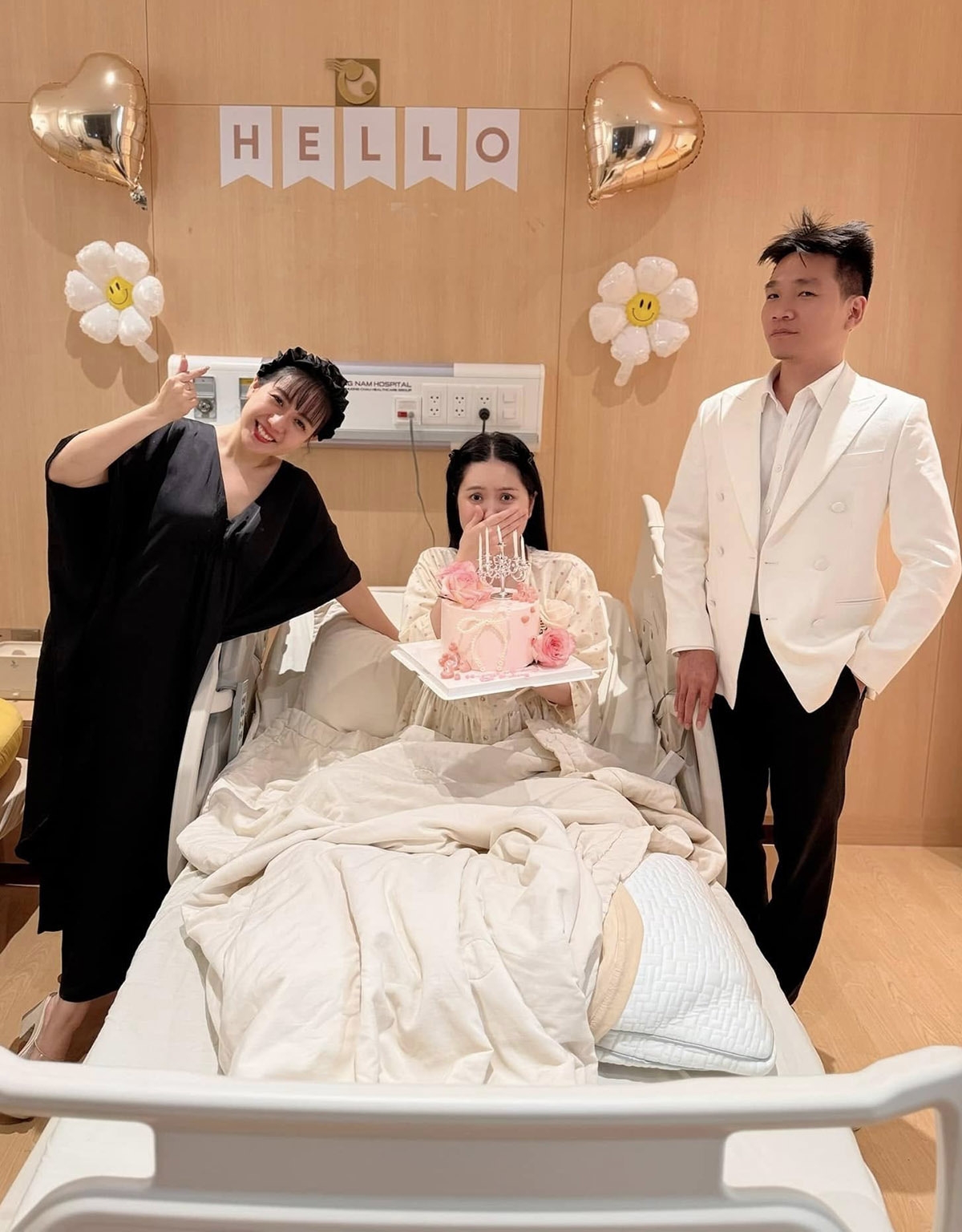 Đoàn Di Băng bất ngờ khi rapper Wowy (phải) và nhà thiết kế Phạm Đăng Anh Thư (trái) đến bệnh viện tặng bánh kem, mừng sinh nhật cô trên giường bệnh.