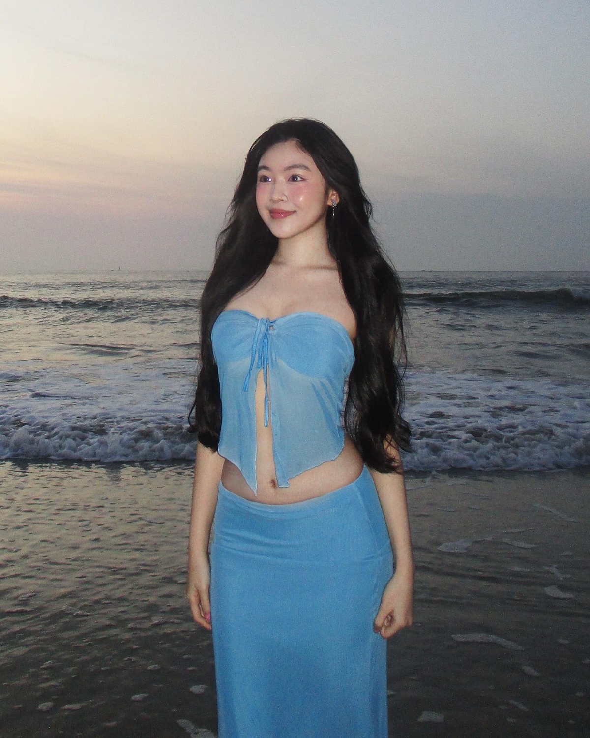 Lọ Lem (Thảo Linh) tung bộ ảnh "bình minh trên biển", khoe sắc vóc dáng gợi cảm, do chính ba Quyền Linh chụp. Cô diện trang phục hai mảnh màu xanh, tôn trọn 3 vòng quyến rũ. (Nguồn: FBNV)