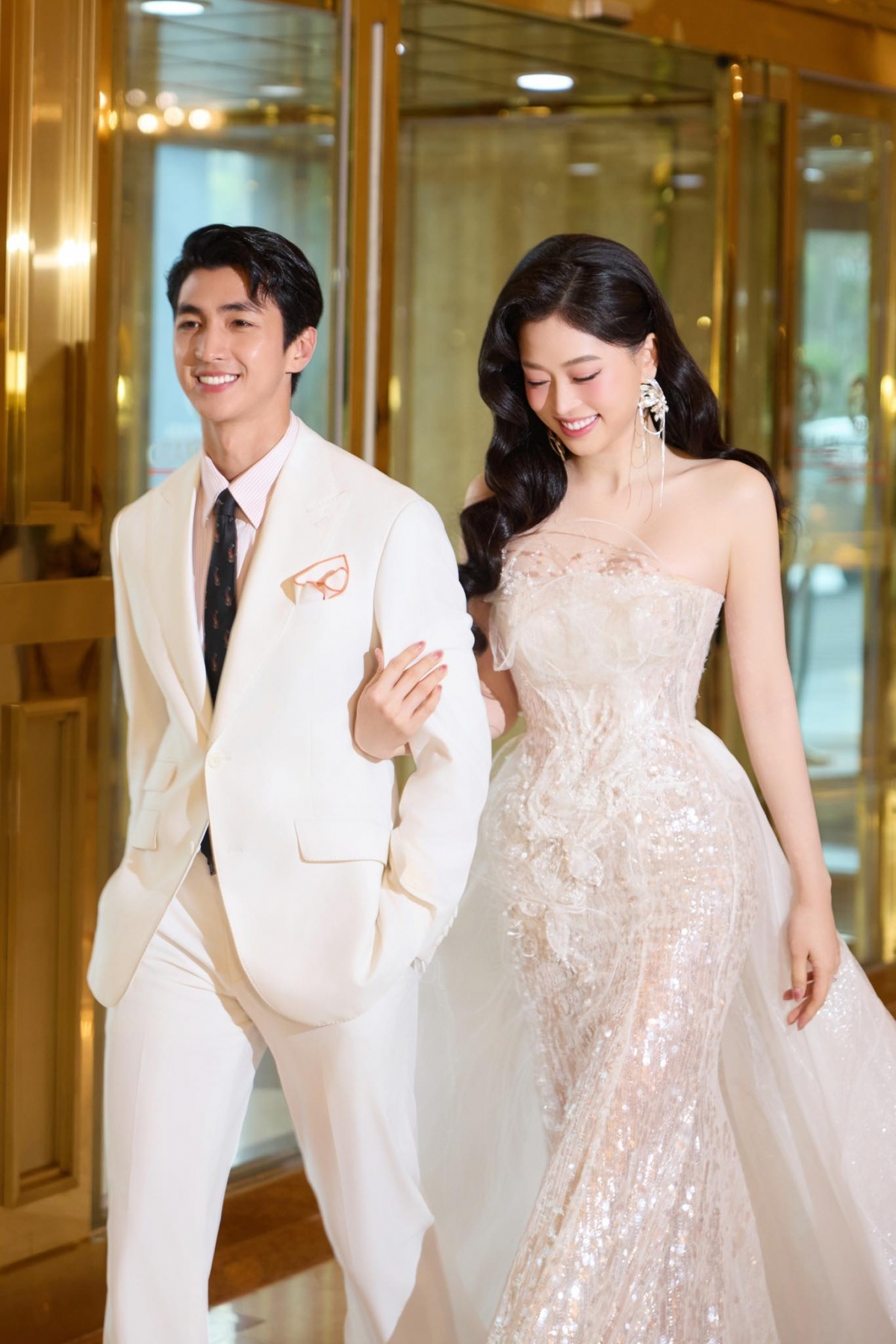 Vợ chồng Bình An – Phương Nga diện đồ màu đồng điệu, tình tứ tay trong tay khi đi sự kiện. (Nguồn: FBNV)
