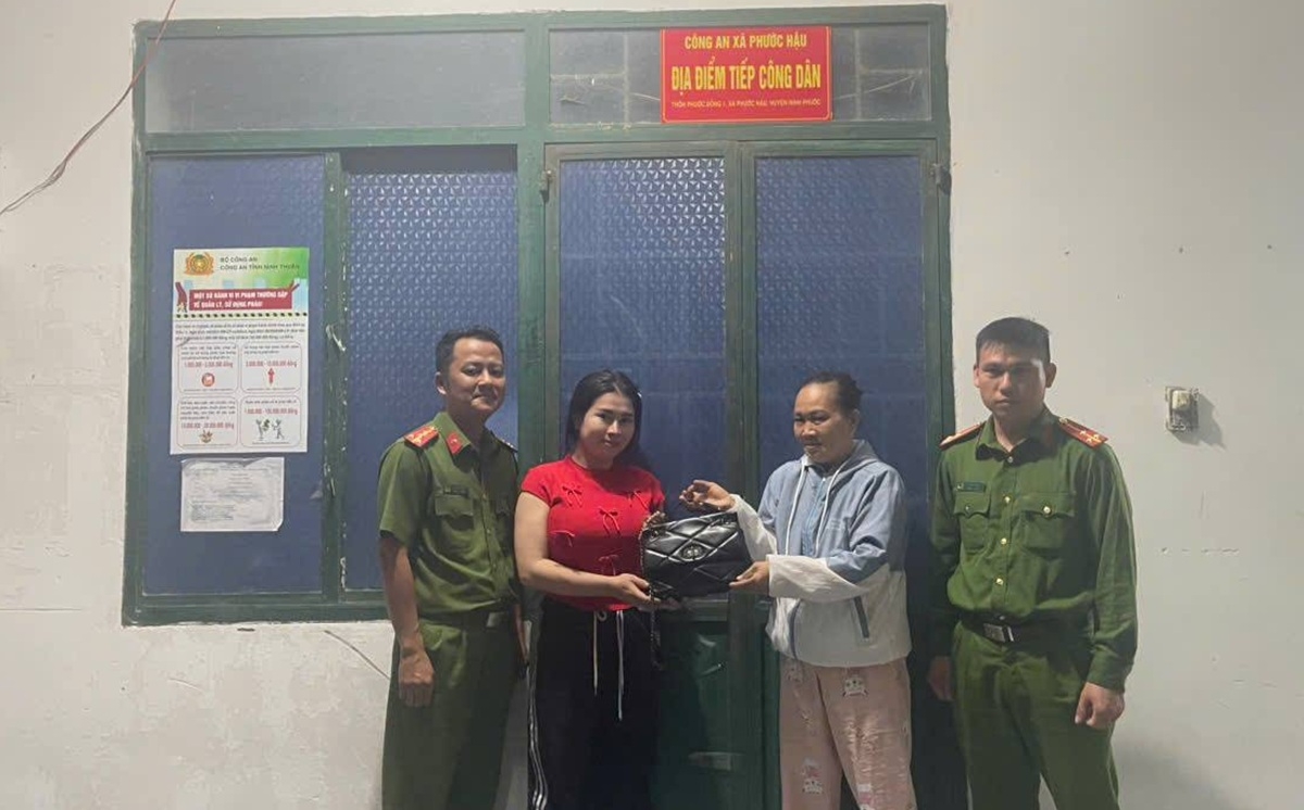 Chị Nhiên (áo đỏ) nhận lại số tài sản mà mình đã đánh mất. Ảnh: CANT