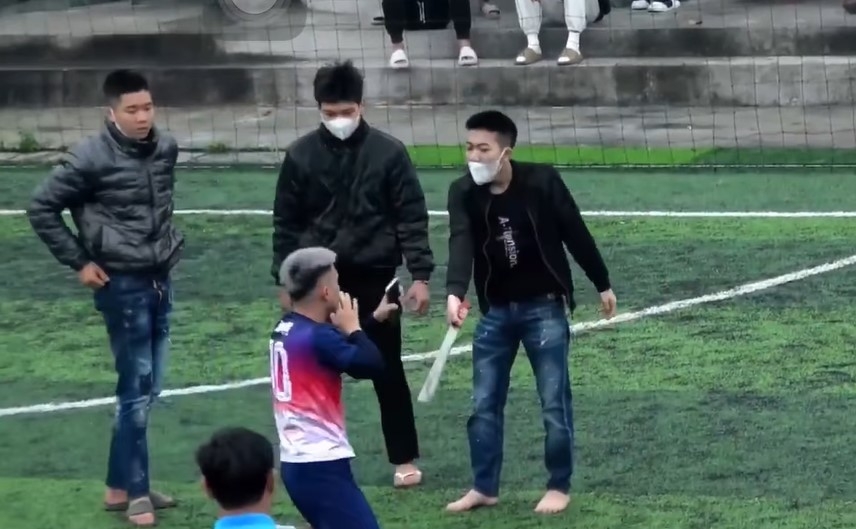 Các đối tượng hành hung và dùng hung khí đe dọa một thanh niên tại sân bóng