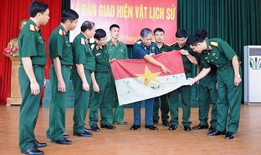 Đại tá Hoàng Phục Hưng giới thiệu Lá cờ giải phóng trong lễ bàn giao hiện vật lịch sử của Trung đoàn 98 cho Bảo tàng Lịch sử Quân sự Việt Nam. (Ảnh: Báo Pháp luật)