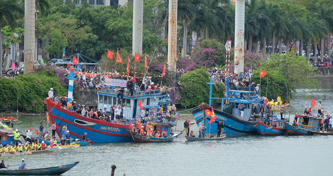 Bà con lên các tàu cá dưới sông để cổ vũ các đội đua