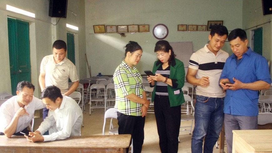 Cán bộ xóm Khuân Nang, xã Liên Minh, Võ Nhai, hướng dẫn người dân cài đặt ứng dụng định danh điện tử VNeID trên điện thoại thông minh tại nhà văn hóa xóm.