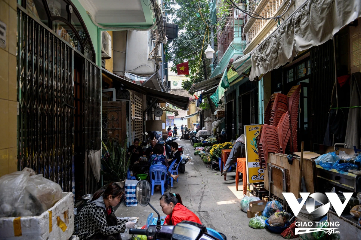 Bên trong cổng làng Hồ Khẩu là chợ họp nhộn nhịp, người mua, người bán.