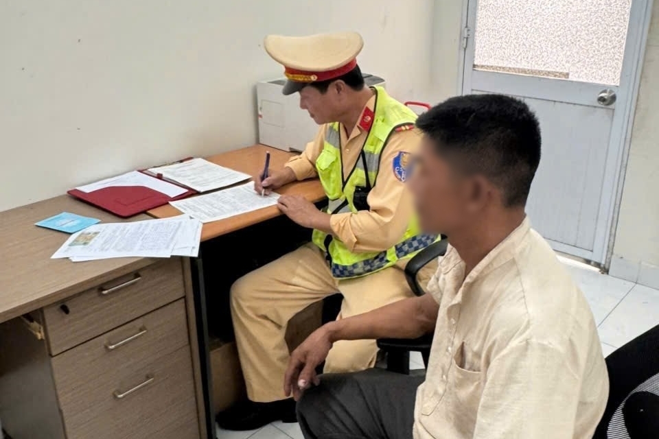 Tài xế sử dụng điện thoại khi lái xe bị CSGT lập biên bản, xử phạt.