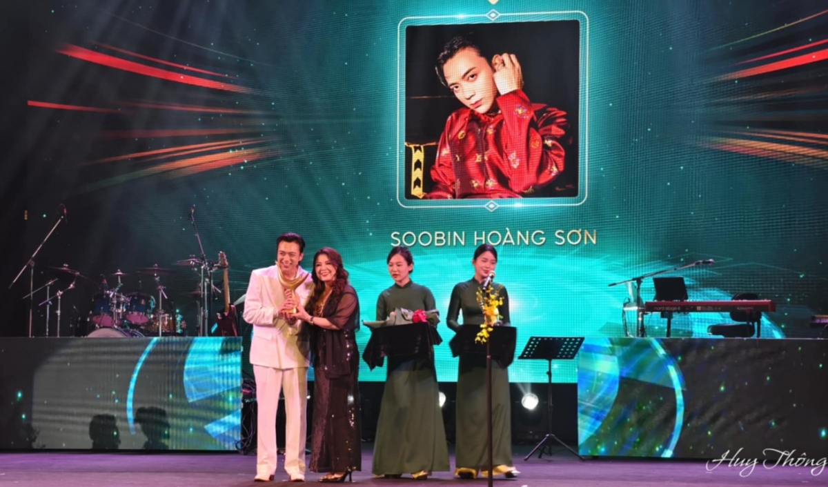 Nghệ sĩ Nhân dân Thái Bảo lên sân khấu công bố kết quả và trao giải hạng mục Nam ca sĩ của năm. Nam ca sĩ của năm thuộc về ca sĩ SOOBIN giúp anh hoàn tất hat-trick ngoạn mục với 3 giải thưởng của mùa giải Cống hiến năm nay. (Ảnh: Báo Thể thao &amp; Văn hóa/TTXVN)