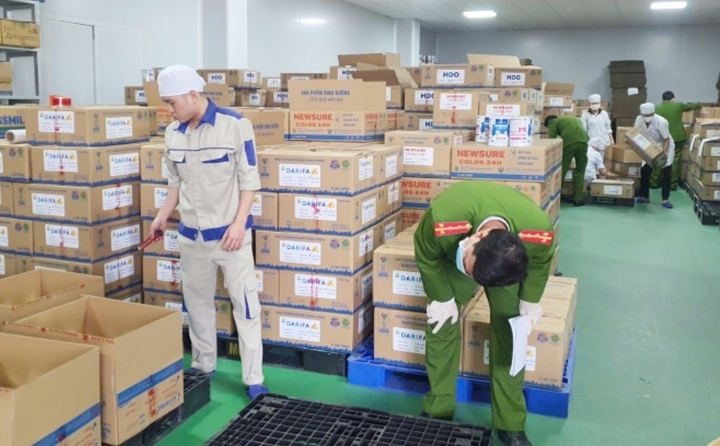 Công an kiểm tra sản phẩm sữa giả. (Ảnh: CAND)