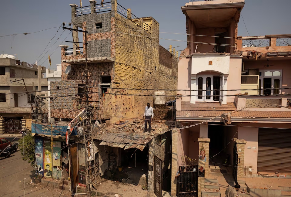 Một người đàn ông đứng giữa đống đổ nát trên mái của một ngôi nhà bị hư hại, sau chiến dịch quân sự của Pakistan nhằm vào Ấn Độ, tại Rehari, Jammu, ngày 10/5/2025. Ảnh: Reuters