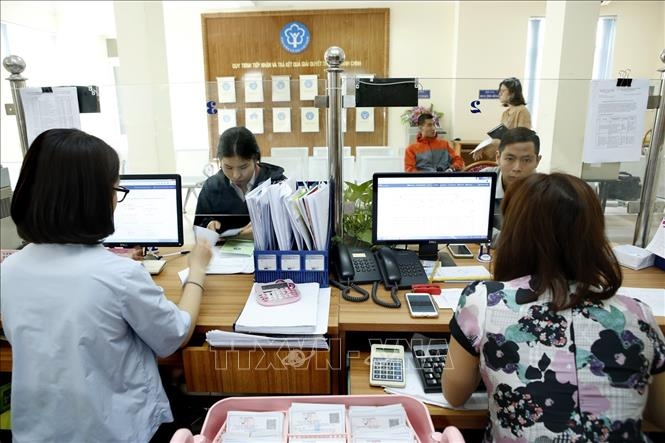 Giải quyết thủ tục hành chính tại BHXH địa phương. Ảnh: TTXVN