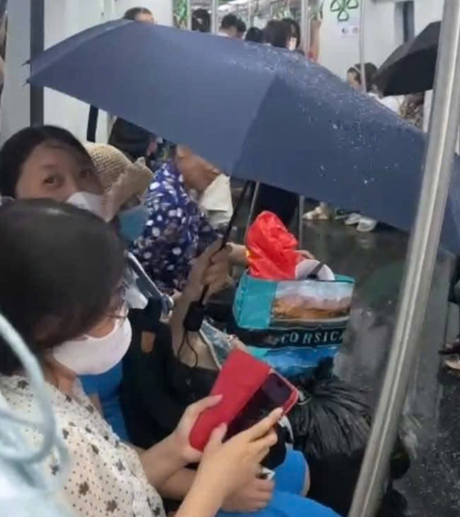 Hành khách đi tàu Cát Linh - Hà Đông phải che ô vì nước dột từ trên nóc tàu xuống.