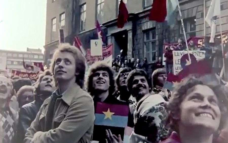 Người dân Thụy Điển hân hoan giương cờ Mặt trận Dân tộc giải phóng miền Nam Việt Nam và chân dung Chủ tịch Hồ Chí Minh… trước văn phòng đại diện của Mặt trận ở Stockholm ngày 30/4/1975 để chào mừng Đại thắng mùa Xuân của Việt Nam (ảnh trích xuất từ phim Victory Vietnam).