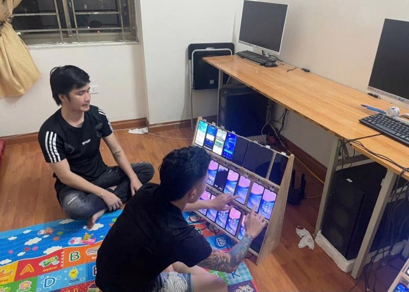 Đối tượng sử dụng điện thoại di động phục vụ hành vi đánh bạc, chuyển tiền. (Ảnh: CATB)