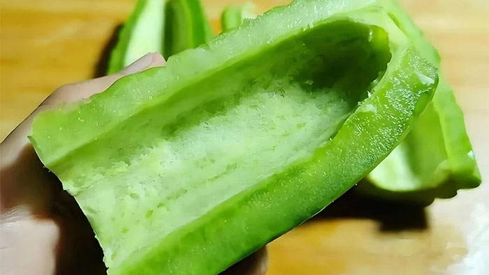 Lớp màng trắng cạo sạch sẽ giúp mướp đắng giảm 90% vị đắng. (Ảnh: Sohu)