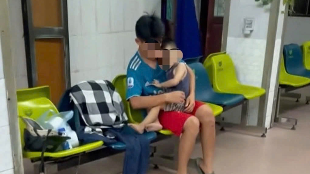Cháu bé ở ngoài hành lang đợi cấp cứu tại bệnh viện. Ảnh: Cắt từ clip