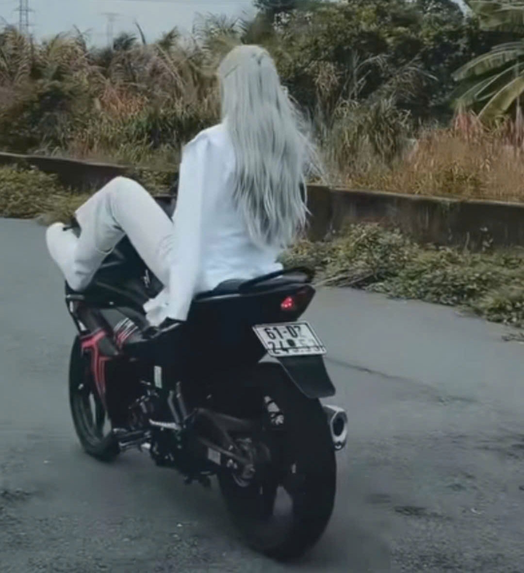 Người này dùng chân hất đầu xe lên 