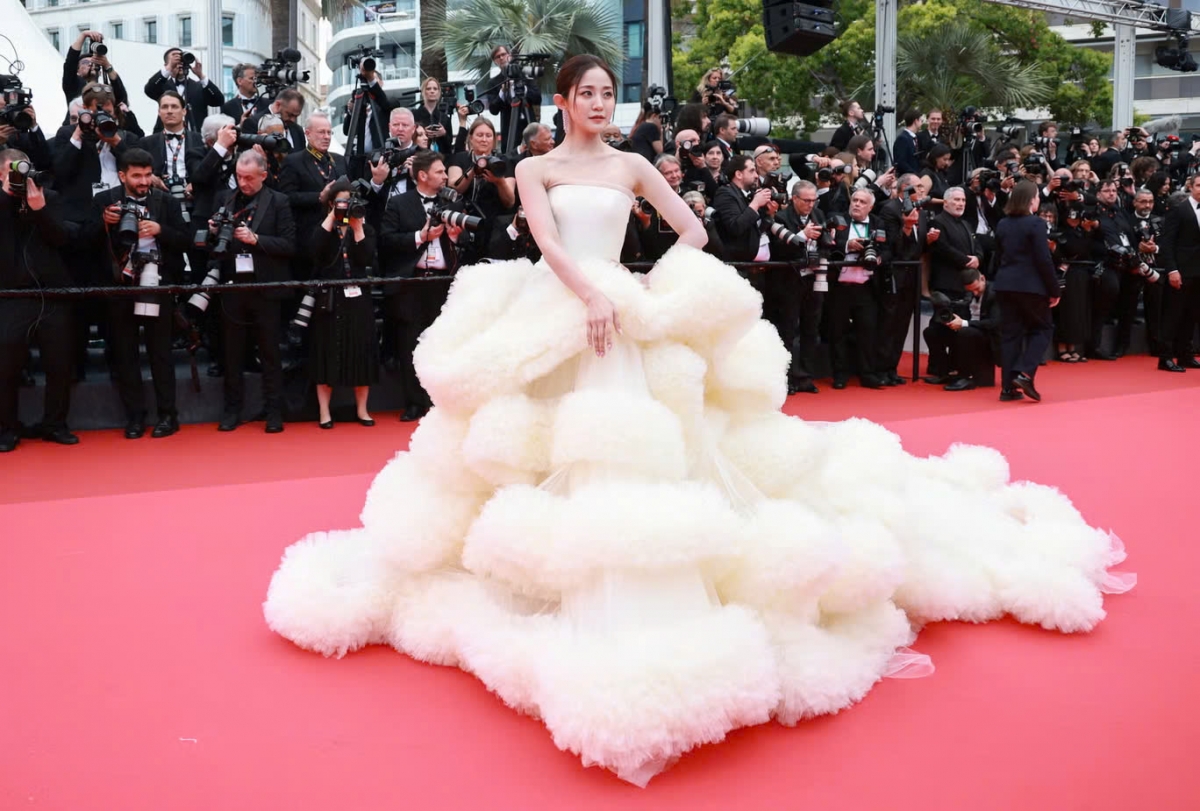 Nữ diễn viên Wan Qianhui phá vỡ quy định không mặc đồ quá “thùng thình” trên thảm đỏ Liên hoan phim Cannes 2025 khi diện chiếc váy màu kem “bồng bềnh như mây”. Thiết kế phồng xòe không có điểm nhấn ở eo hay vai, khiến Wan Qianhui trông nhỏ bé, lọt thỏm trong lớp vải dày đặc.