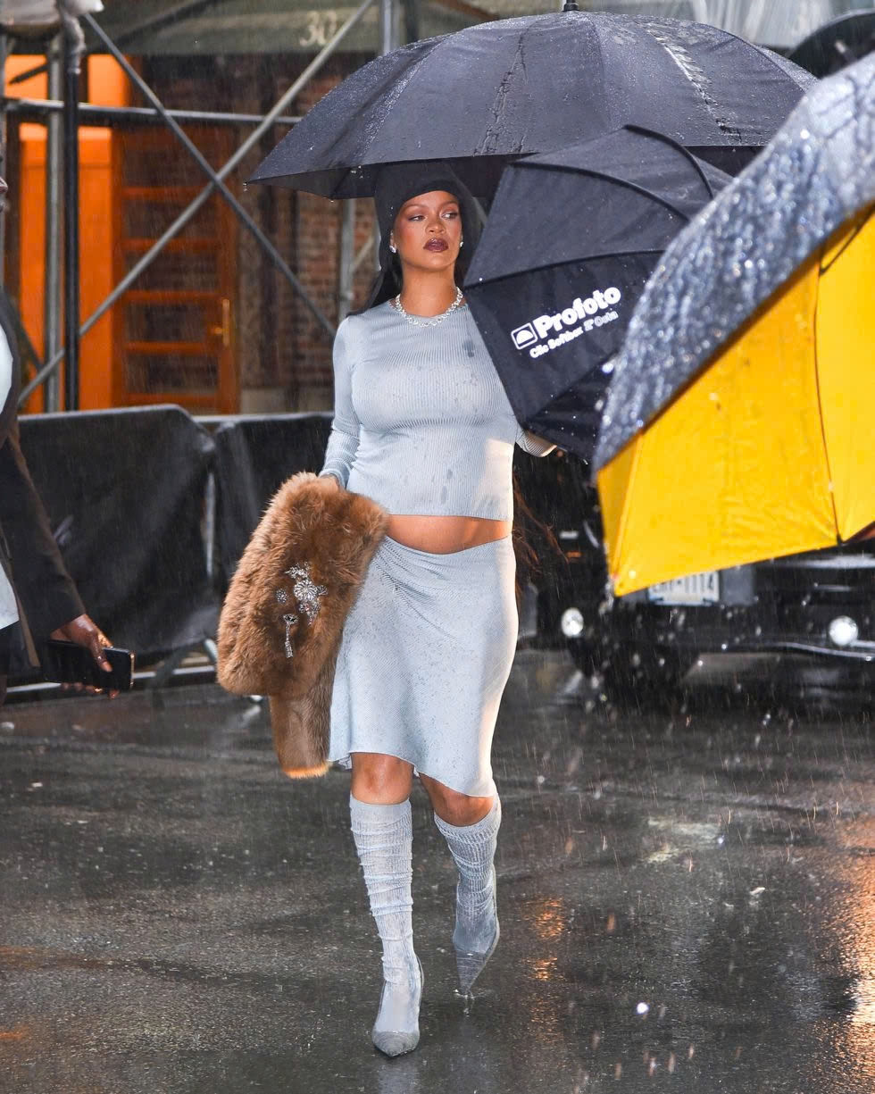 Trước đó, Rihanna xuất hiện tại khách sạn Carlyle trong set đồ xanh nhạt Miu Miu Thu 2025, áo gân tay dài, váy ngắn, tất cao đầu gối nhét vào giày xám. Cô hoàn thiện phong cách với mũ cloche đen và khăn choàng lông nâu.
