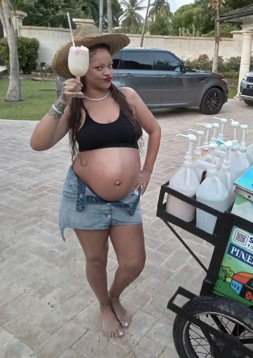 Ngày 1/7/2023, Rihanna thưởng thức kem đá bào gừng dừa trước biệt thự ở Barbados, diện áo ngực thể thao đen và quần short denim sáng màu cạp thấp. Cô kết hợp vòng cổ kim cương, vòng tay tennis và đội mũ rơm, tạo nên phong cách giản dị.