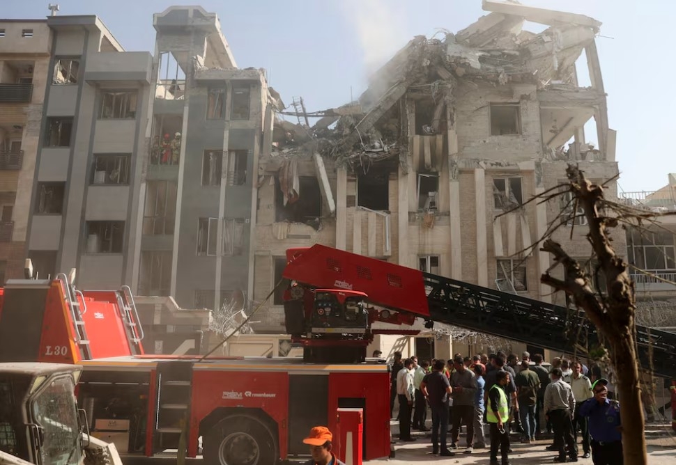 Lực lượng cứu hộ tiếp cận hiện trường một tòa nhà hư hại sau cuộc tấn công của Israel. Ảnh: Reuters