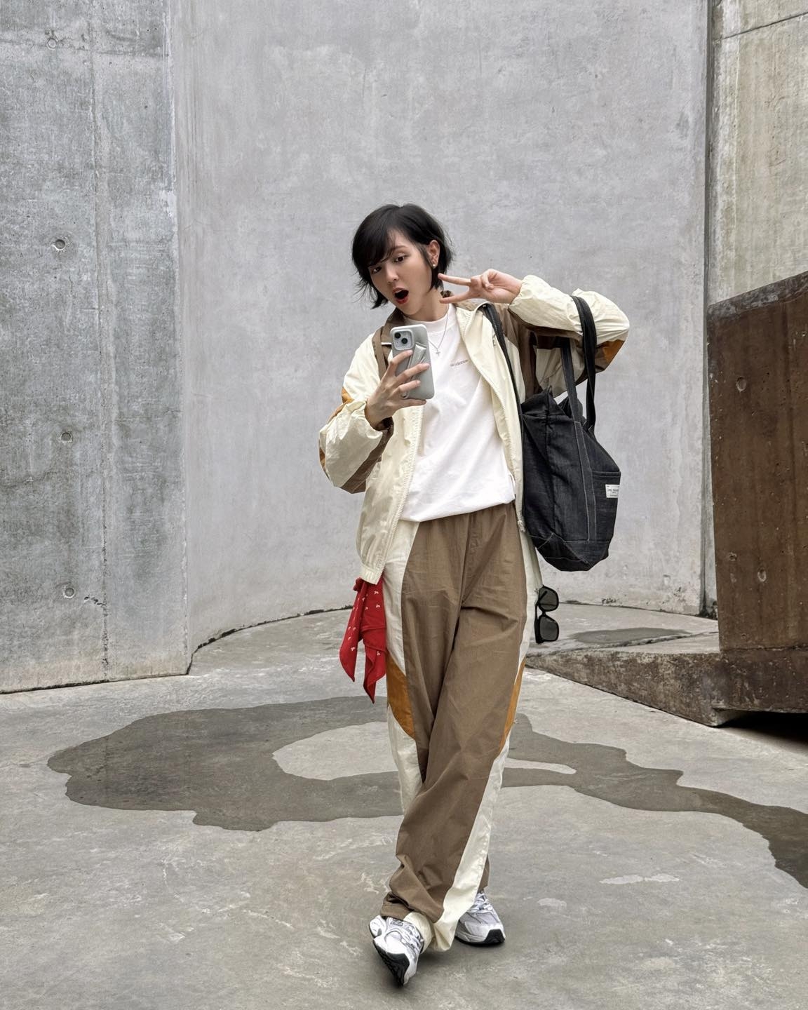 Người đẹp sinh năm 1997 cũng lựa chọn phong cách thời trang mang hơi hướng athleisure – kết hợp giữa thời trang thể thao và tính ứng dụng hàng ngày. Cô mặc một bộ đồ thể thao phối màu be, nâu, trắng. Bên trong là một áo thun trắng, giúp cân bằng tổng thể trang phục. Hải Tú chọn khăn bandana và giầy sneaker làm điểm nhấn cho trang phục.