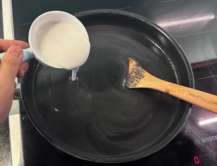Đổ ra nồi hoặc chảo chống dính, cho thêm nước cốt dừa vào khuấy đều.