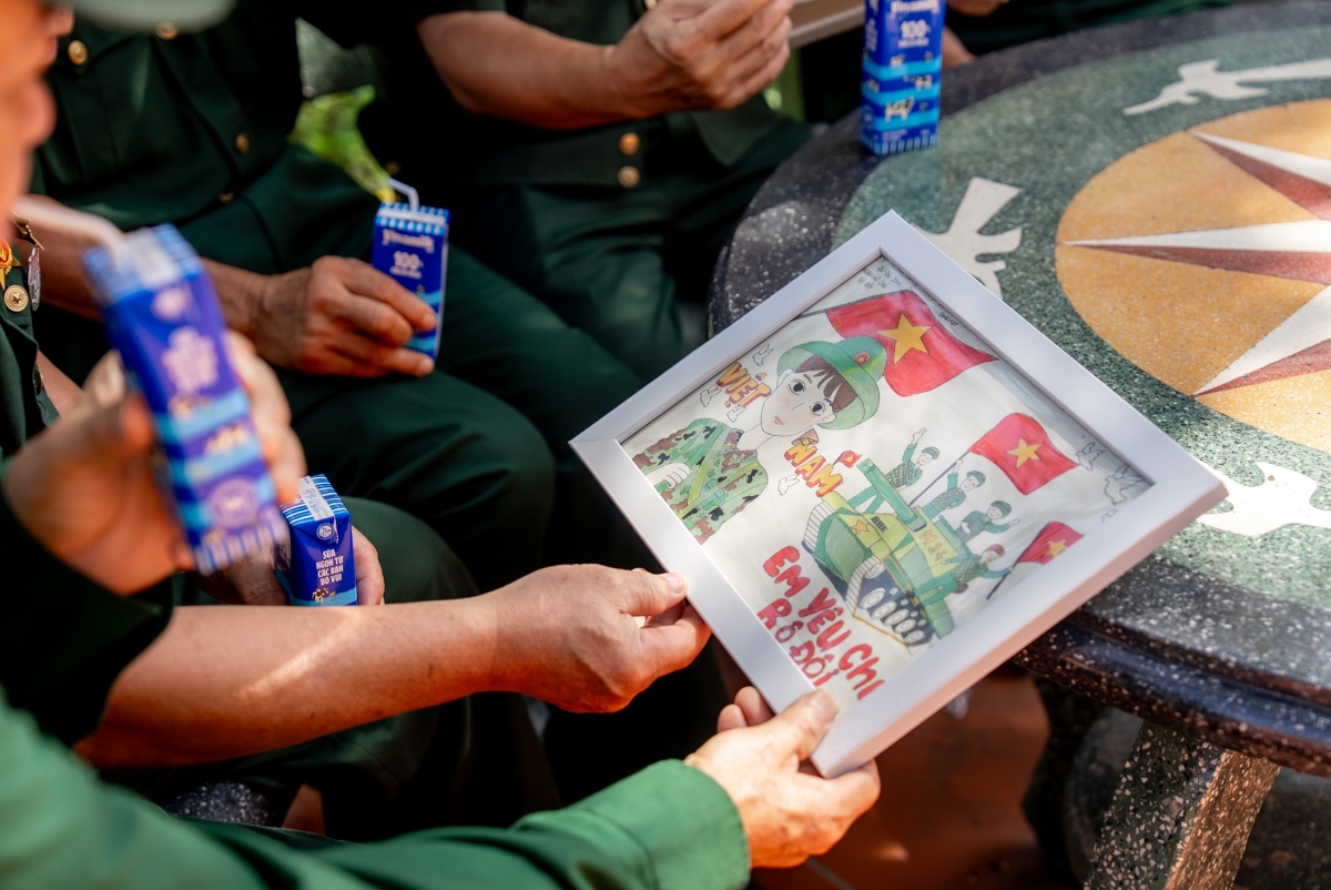 Các cựu chiến binh chăm chú đọc những dòng chữ nhỏ, được các em gửi kèm trong mỗi bức tranh. (Ảnh: Duy Cường)