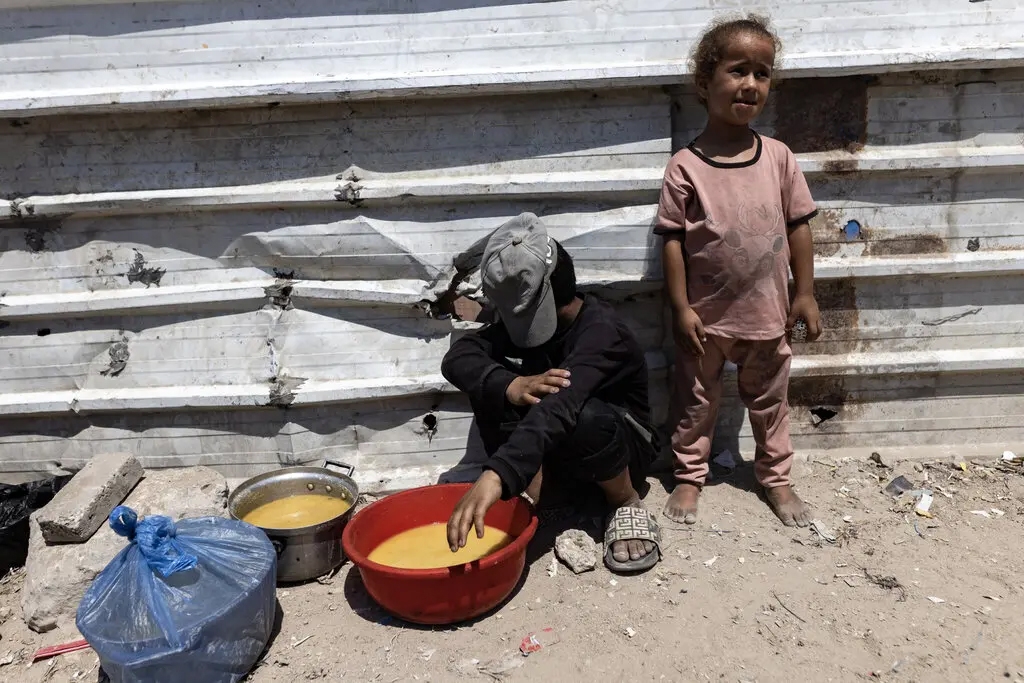 Hai em nhỏ đứng bên ngoài một bếp ăn từ thiện ở thành phố Gaza, ngày 23/7/2025. Ảnh: NY Times