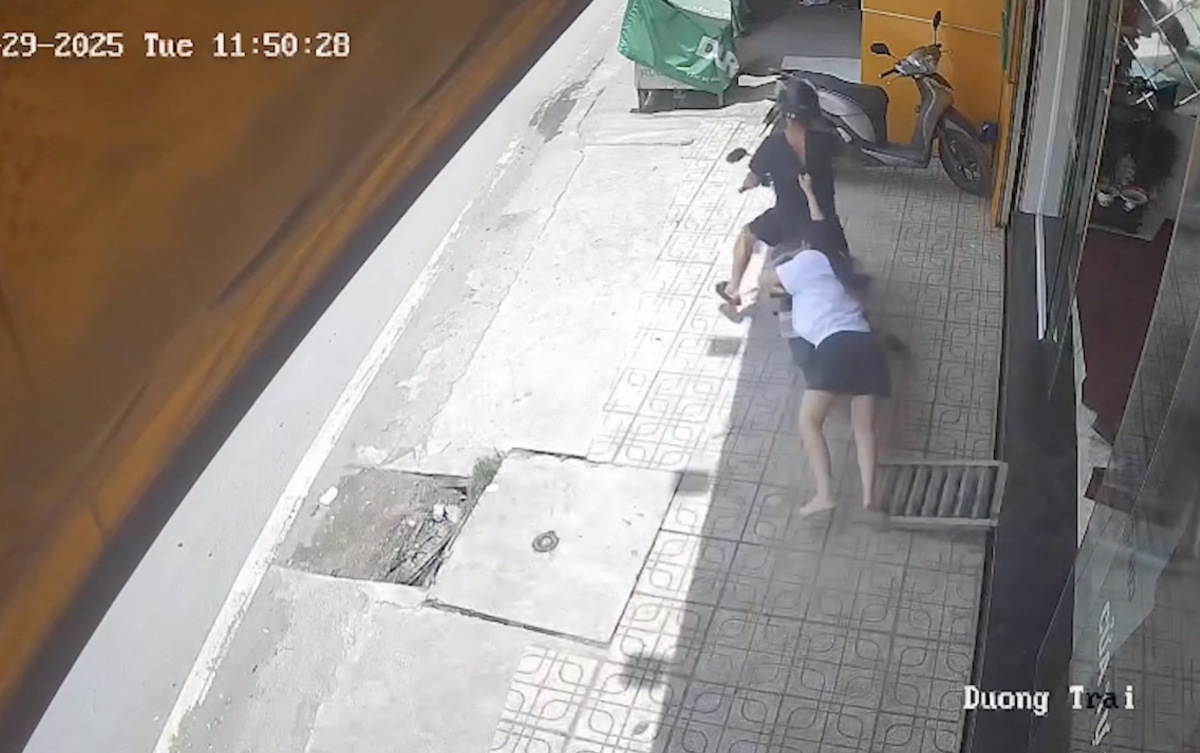 Nữ nhân viên của tiệm vàng bị nghi can cướp kéo lê. (Ảnh cắt từ camera an ninh)