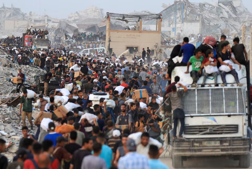 Người Palestine mang hàng viện trợ vào Dải Gaza qua ngả Israel, tại Beit Lahia, phía bắc Dải Gaza, ngày 29/7/2025. Ảnh: Reuters