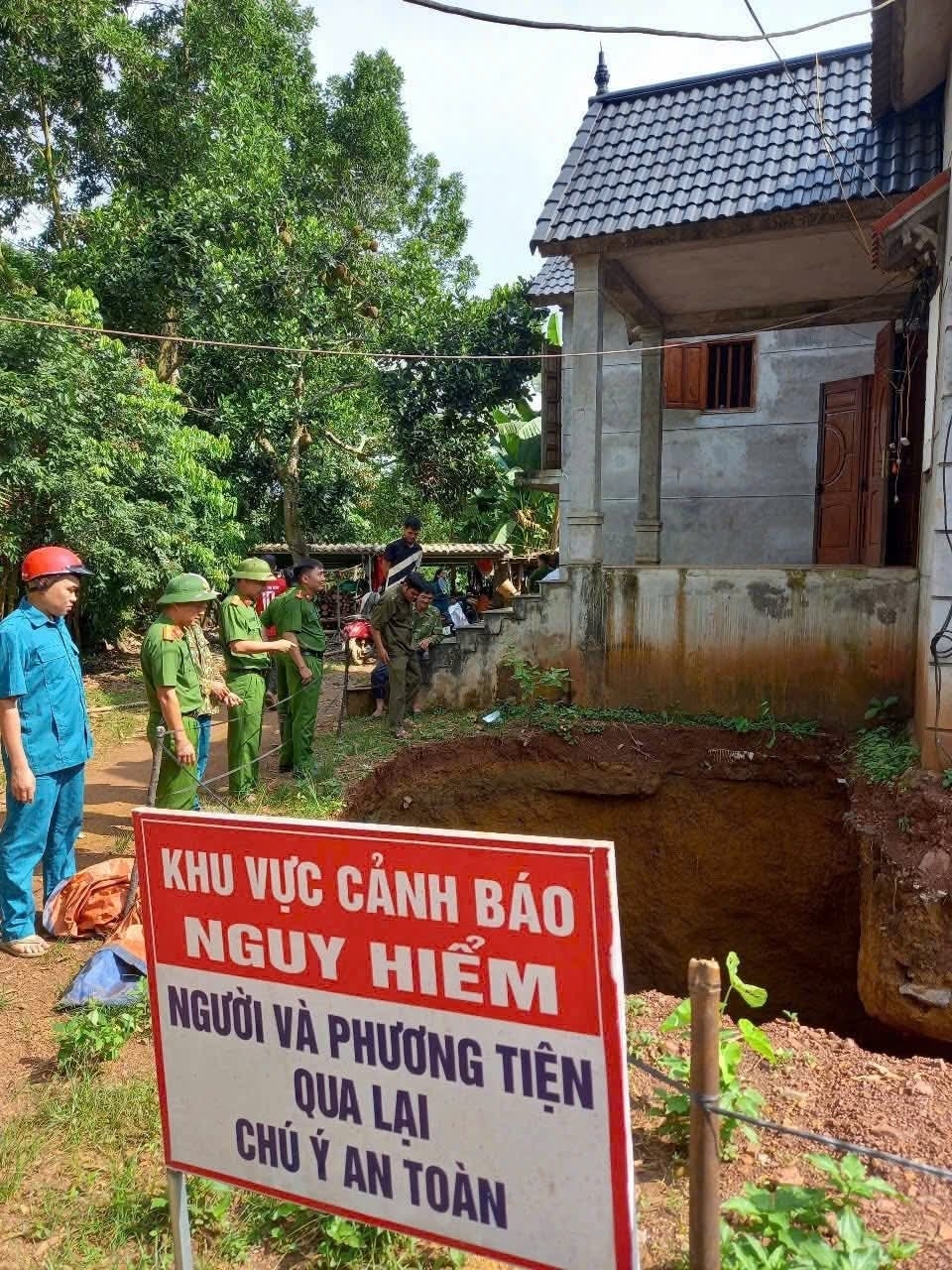 Chăng dây, cắm biển báo hố sụt lún ngay sát nhà dân. Ảnh: Công an tỉnh Phú Thọ.