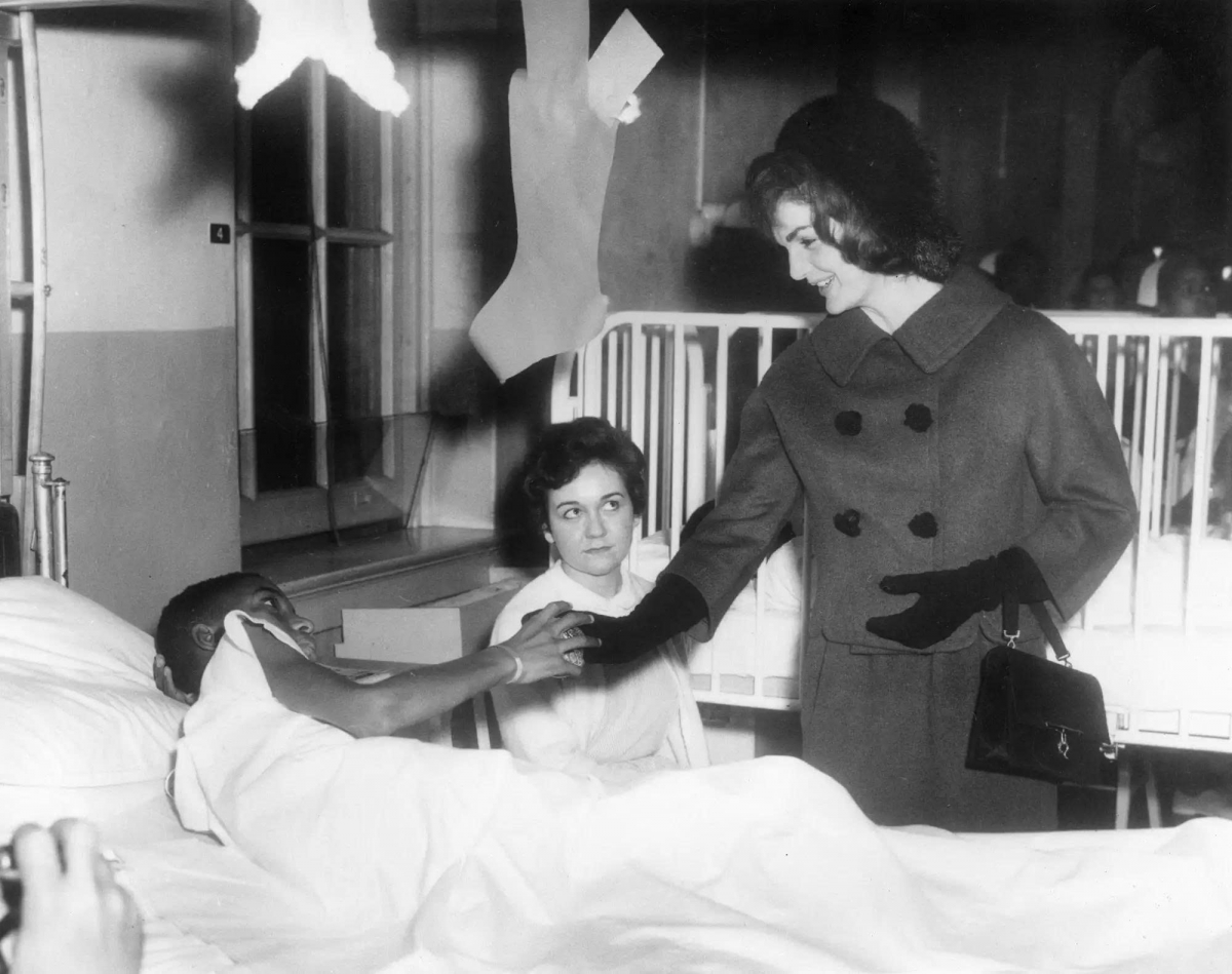 Ngày 12/12/1961, phu nhân Jackie tới thăm một bệnh viện dành cho trẻ em. Bà trò chuyện và nắm tay một bé trai đang nằm viện, diện chiếc áo khoác dạ cổ điển cùng mũ, găng tay và túi xách,  đúng phong cách đậm chất Jackie.