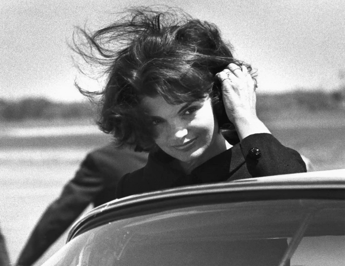 Khoảng năm 1964, Jackie Kennedy xuất hiện tại sân bay Barnstable (Hyannis Port) để ghi hình một chương trình truyền hình quốc tế tưởng niệm chồng mình, nhân ngày sinh thứ 47 của ông. Bà vuốt tóc trong gió trước khi lên xe.
