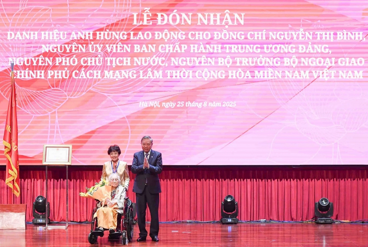 Tổng Bí thư Tô Lâm, thay mặt Đảng và Nhà nước trao tặng danh hiệu Anh hùng Lao động cho bà Nguyễn Thị Bình. (Ảnh: Nguyễn Hồng)