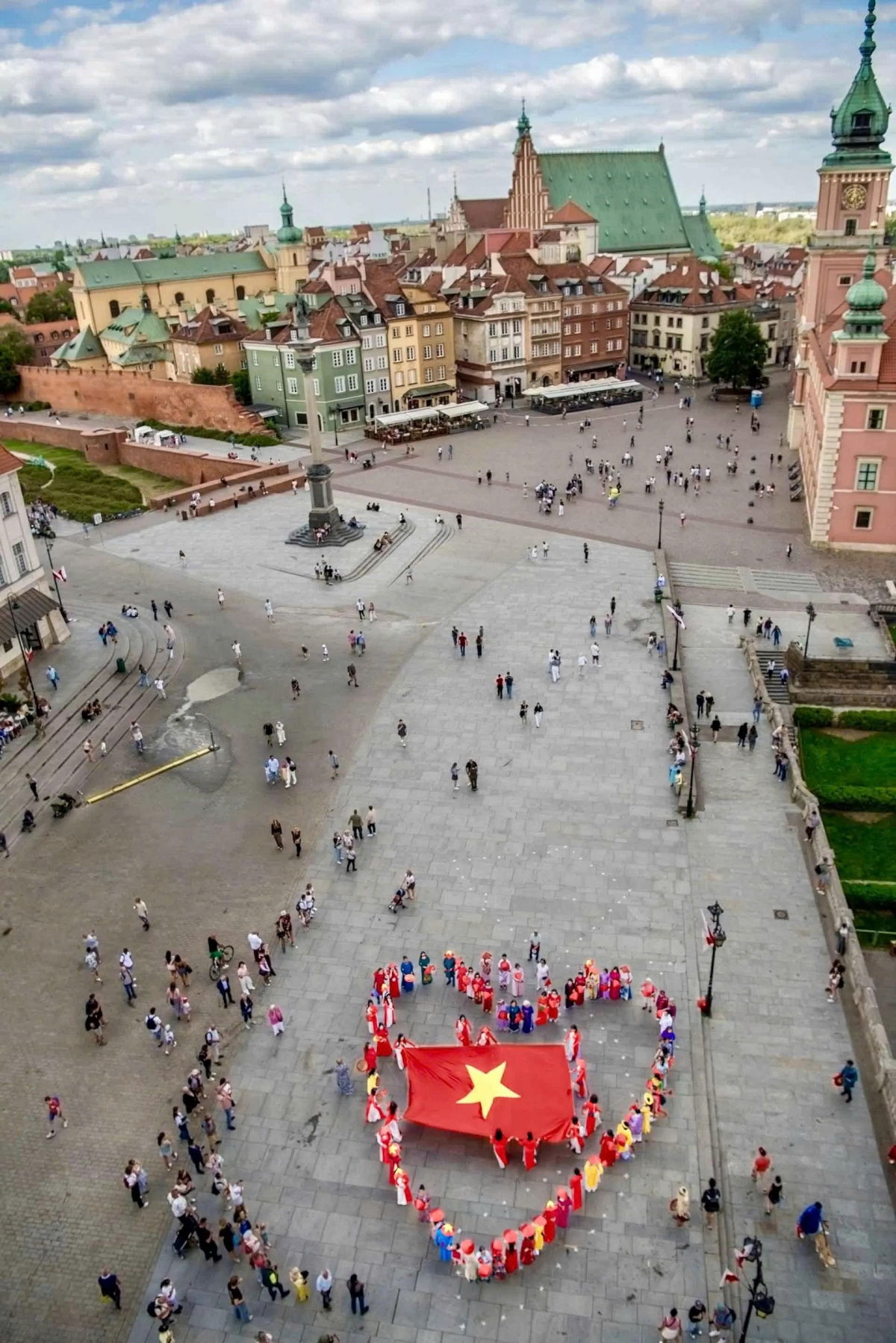 Vietnamese expats in Ao Dai form a heart shape with the national flag at its centre..